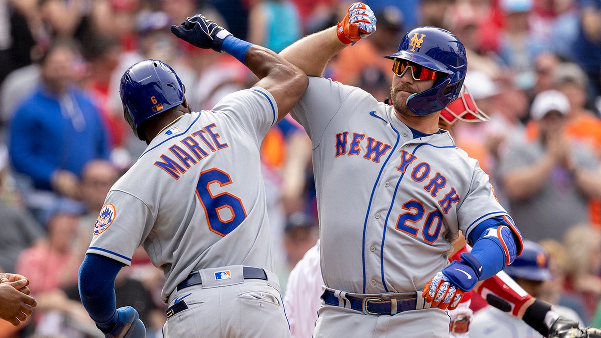 New York Mets' Pete Alonso (20) celebrates with Starling Marte (6) after hitting a 3-run home run during the sixth inning of a baseball game against the Philadelphia Phillies, Wednesday, April 13, 2022, in Philadelphia.