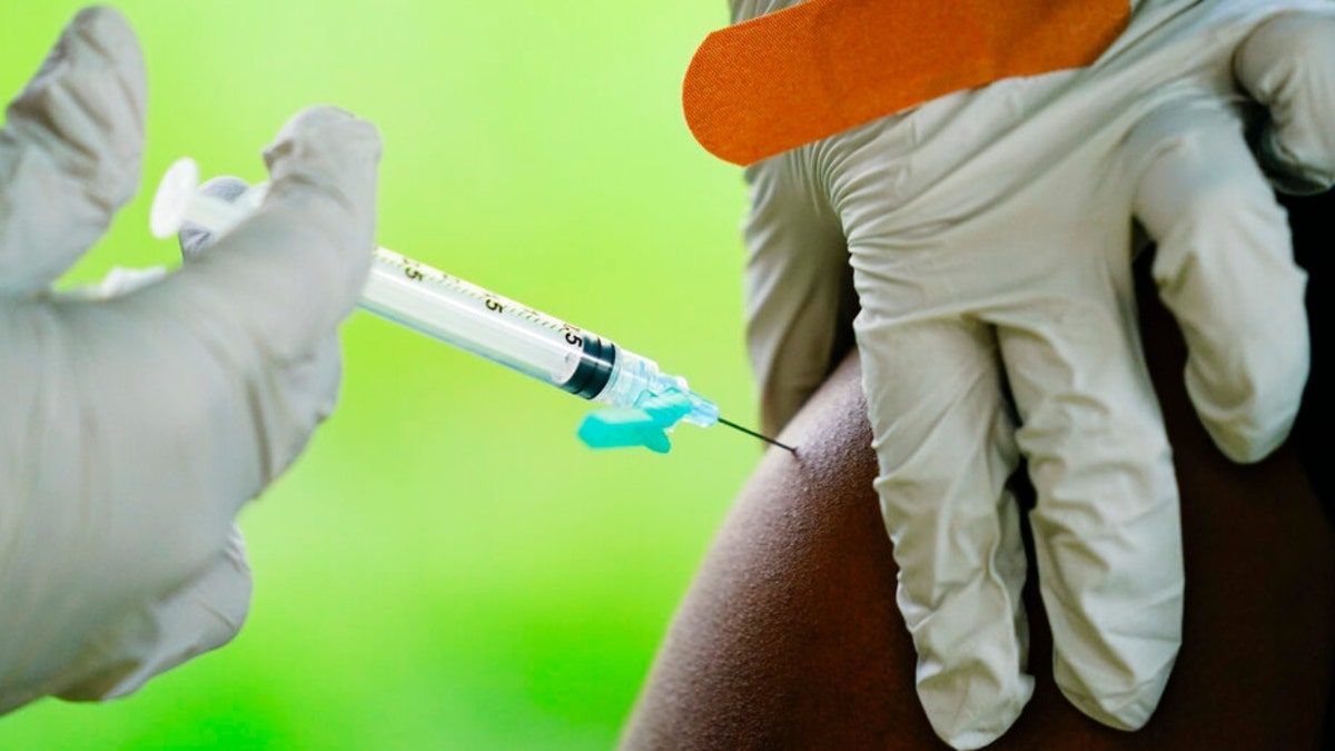 A health worker administers the Pfizer COVID-19 vaccine