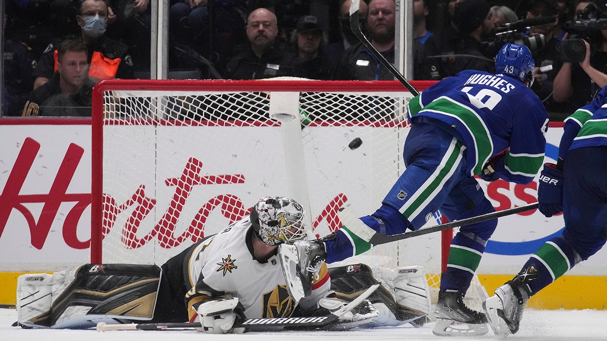 Vancouver Canucks' Quinn Hughes, right, scores against Vegas Golden Knights goalie Robin Lehner during overtime in an NHL hockey game Tuesday, April 12, 2022, in Vancouver, British Columbia.