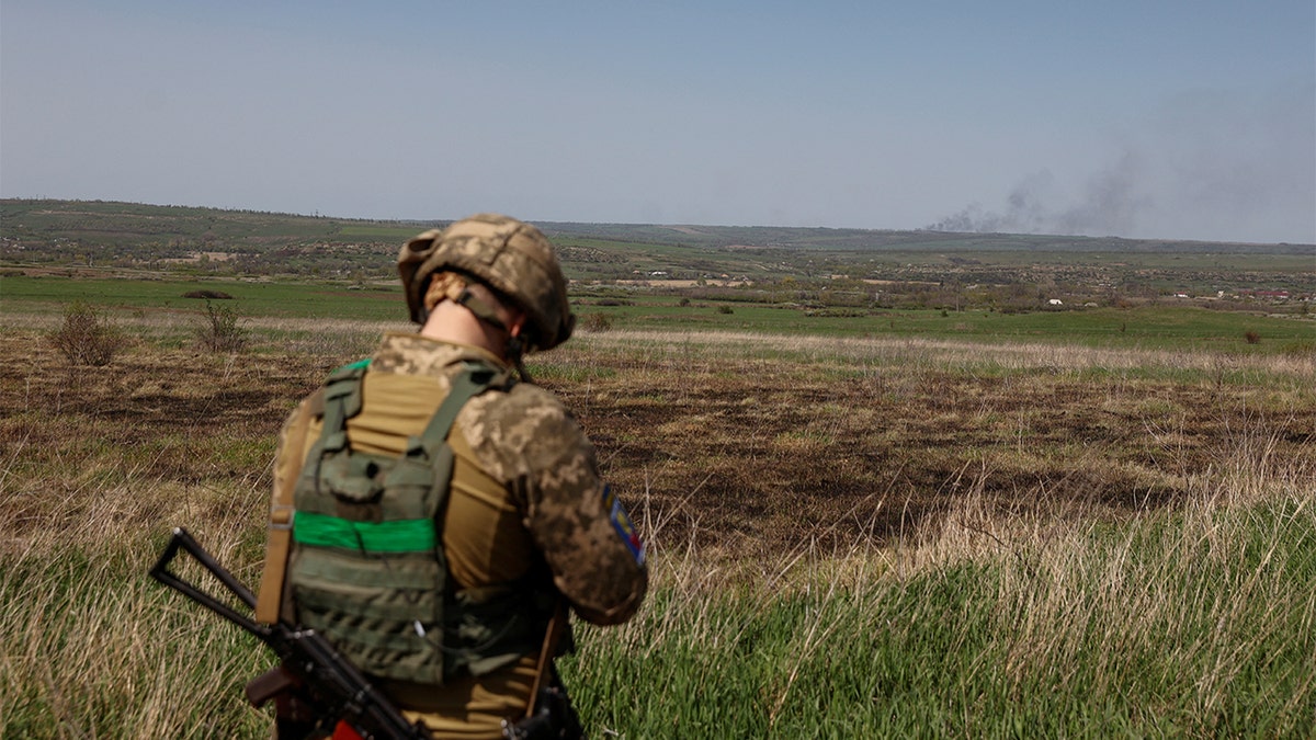 A Ukrainian serviceman looks as smoke rises after a Russian troops shelling, as Russia's attack on Ukraine continues, in Luhansk Region, Ukraine April 26, 2022. REUTERS/Serhii Nuzhnenko