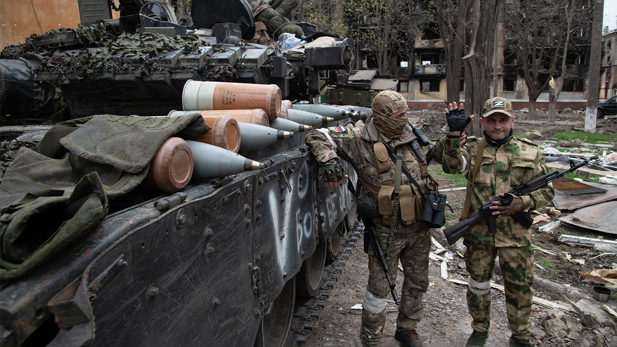 Russian soldiers pose by a T-80 tank in a position close to the Azovstal frontline in the besieged port city of Mariupol. (Photo by Maximilian Clarke/SOPA Images/LightRocket via Getty Images)