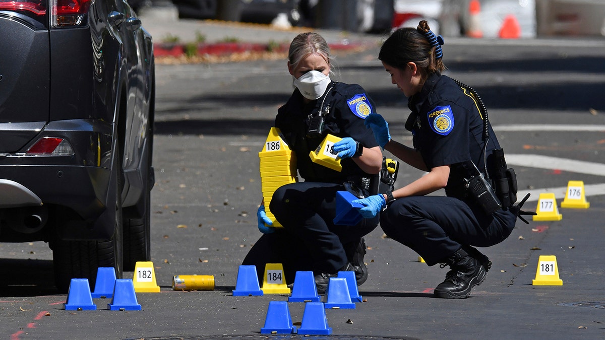 Sacramento Police crime scene investigators place evidence markers on 10th street at the scene of a mass shooting in Sacramento, California, on Sunday, April 3, 2022. 