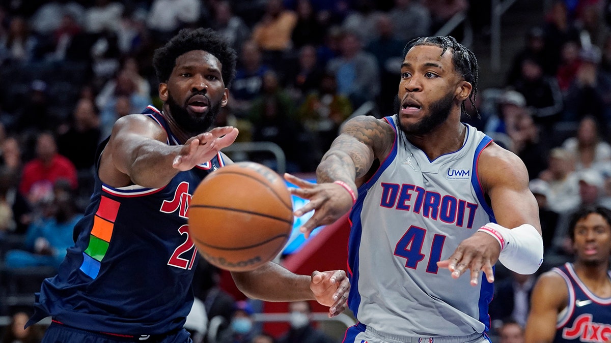 Detroit Pistons forward Saddiq Bey (41) passes the ball as Philadelphia 76ers center Joel Embiid (21) defends during the second half of an NBA basketball game, Thursday, March 31, 2022, in Detroit.