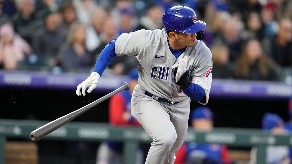 Chicago Cubs' Seiya Suzuki heads to first base as Colorado Rockies shortstop Jose Iglesias mishandles the ball for an error in the third inning of a baseball game Thursday, April 14, 2022, in Denver.
