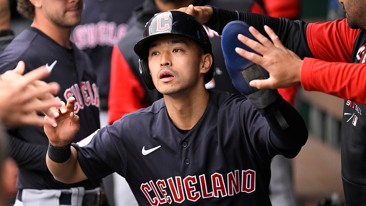 Cleveland Guardians' Steven Kwan is congratulated after scoring against the Kansas City Royals during the first inning of a baseball game, Monday, April 11, 2022, in Kansas City, Mo.