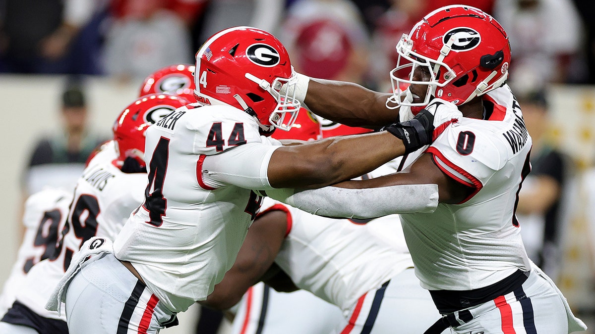 Travon Walker #44 Darnell Washington #0 of the Georgia Bulldogs warm up prior to a game against the Alabama Crimson Tide in the 2022 CFP National Championship Game at Lucas Oil Stadium on January 10, 2022, in Indianapolis, Indiana.