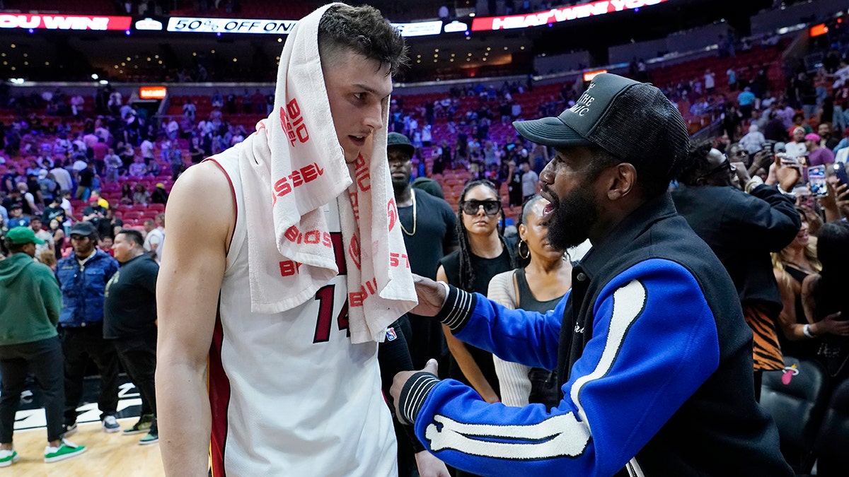 Miami Heat guard Tyler Herro, left, talks with former boxer Floyd Mayweather Jr. after an NBA basketball game between the Heat and Charlotte Hornets, Tuesday, April 5, 2022, in Miami. The Heat won 144-115.