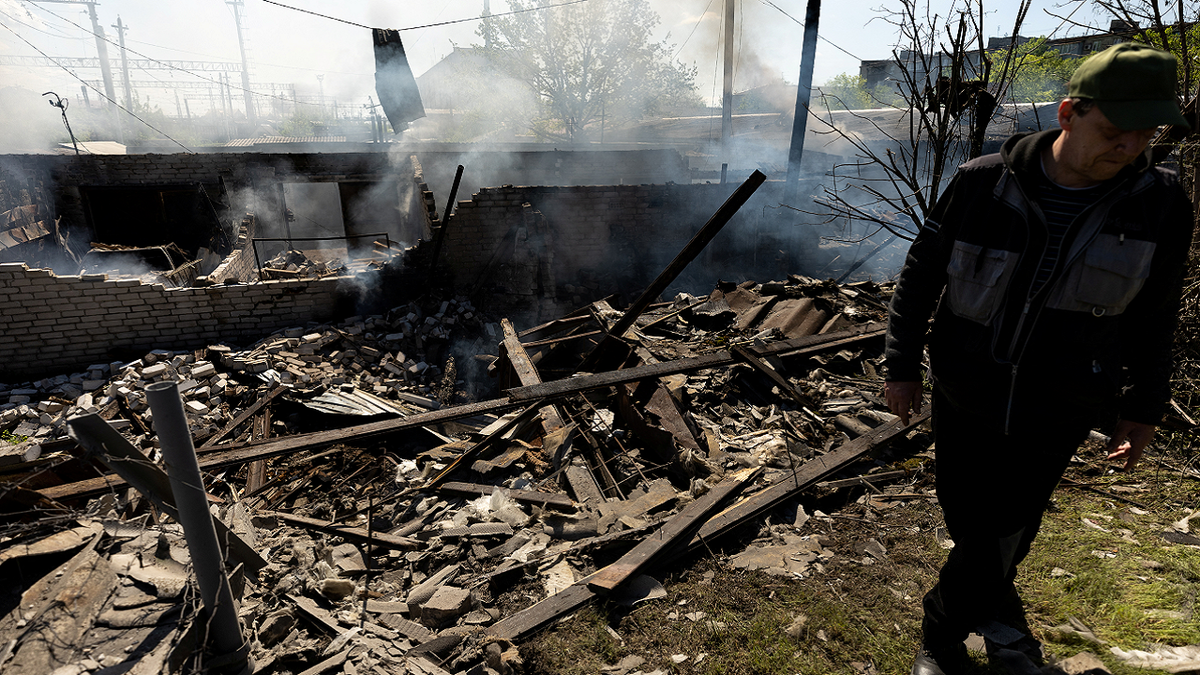 A man stands at the site of a destroyed garage following a military strike near a railway station in Lyman, in the Donetsk region of Ukraine, on Thursday, April 28.