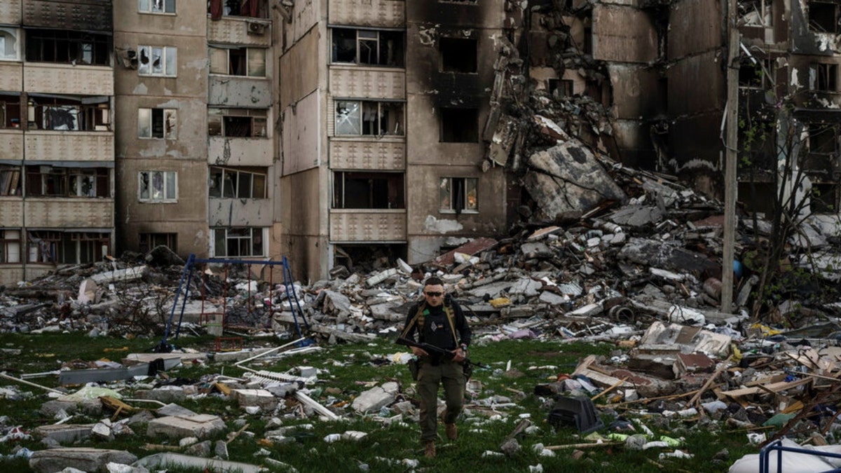 A Ukrainian serviceman walks amid rubble in Kharkiv