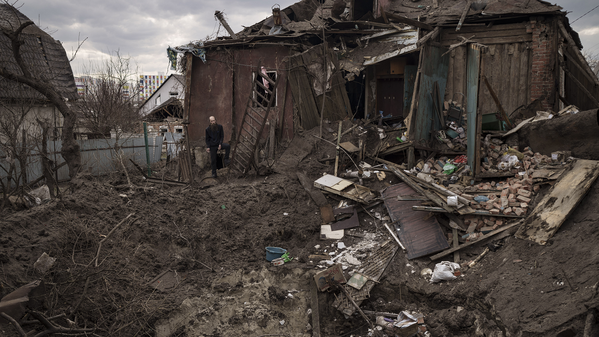Oleg Mezhiritsky stands outside his house, damaged after a Russian attack in Kharkiv, Ukraine, on Friday.