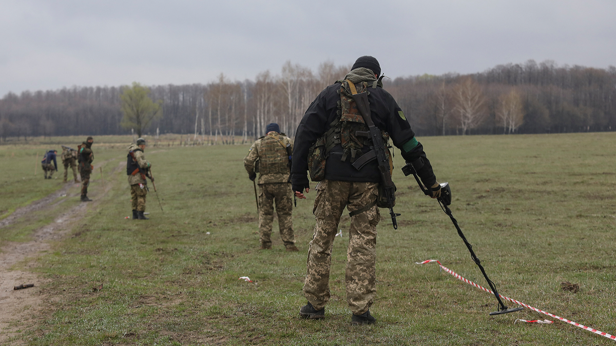 The Ukrainian military inspects an area for mines and non-exploded shells left after Russia's invasion in the Kyiv region on Thursday, April 21.