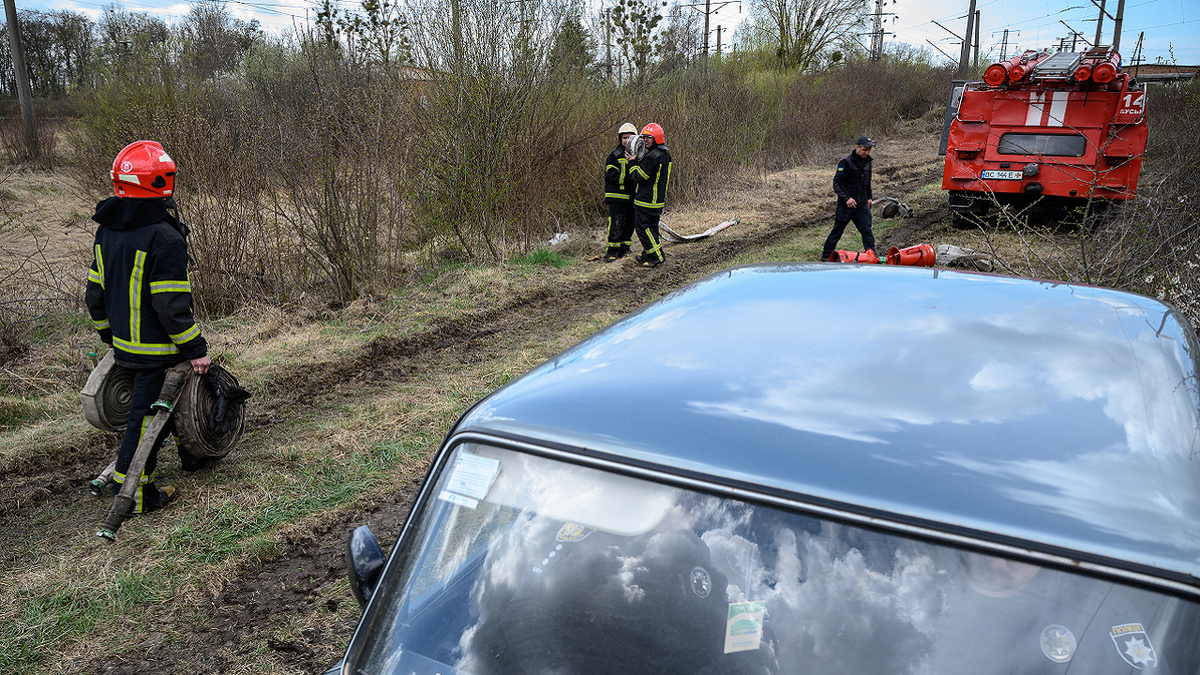 Firefighters carry hoses near the location of a missile strike on April 25, 2022 near Lviv, Ukraine.