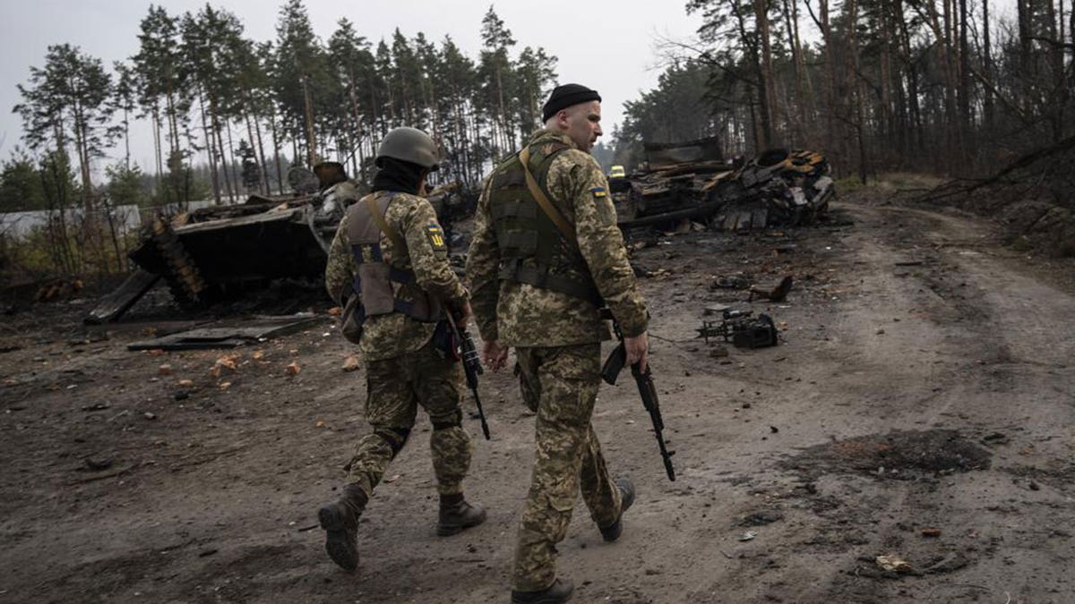 Ukrainian soldiers walk next to destroyed Russian tanks in the outskirts of Kyiv, Ukraine, Thursday, March 31, 2022. Russian forces shelled Kyiv suburbs, two days after the Kremlin announced it would significantly scale back operations near both the capital and the northern city of Chernihiv to "increase mutual trust and create conditions for further negotiations." (AP Photo/Rodrigo Abd)
