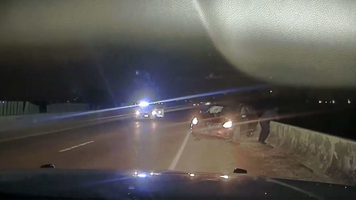 A law enforcement officer leaned over a bridge after a man jumped near Memphis, Tennessee, after a police chase April 17, 2022, in this image from video released by the West Memphis Police Department.