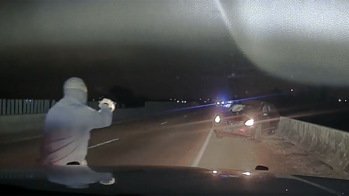 A law enforcement officer approached a car near Memphis, Tennessee, after a police chase April 17, 2022, in this image from video released by the West Memphis Police Department.