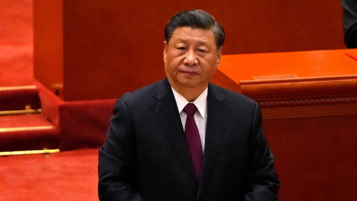 China's Xi Jinping in a black suit at meeting with red background