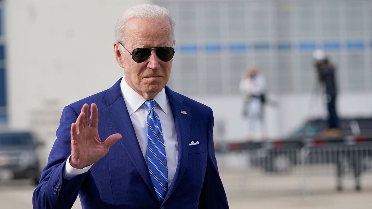 President Joe Biden waves as he walks to speaks to reporters before boarding Air Force One at Des Moines International Airport, in Des Moines Iowa, Tuesday, April 12, 2022, en route to Washington.