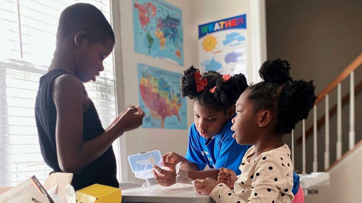 In this undated photo provided by Dalaine Bradley, Ahmad Waller, 11, Zion Waller, 10, and Drew Waller, 7, left to right, study during homeschooling, in Raleigh, N.C. 