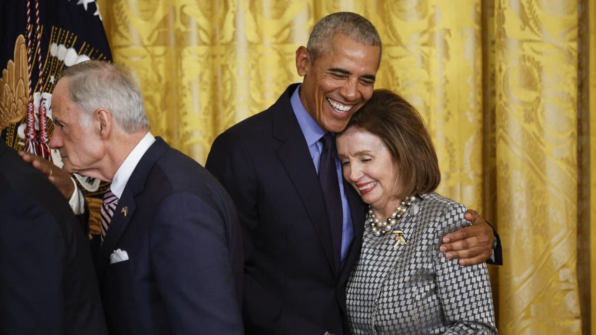 Former President Barack Obama hugs Speaker of the House Nancy Pelosi (D-CA)