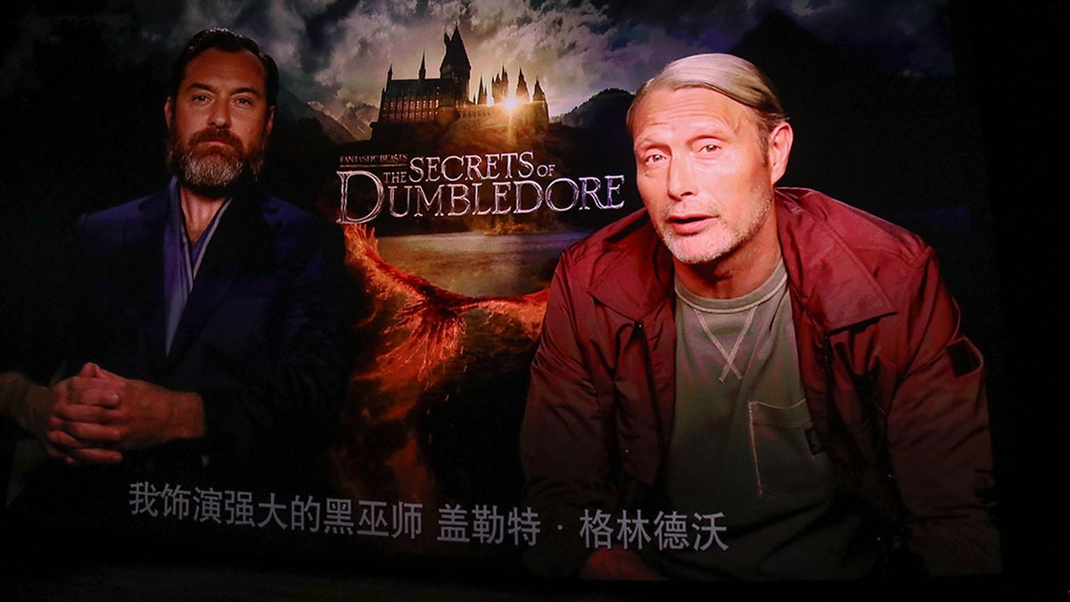 A screen shows actor Jude Law and actor Mads Mikkelsen speaking via video link during 'Fantastic Beasts: The Secrets of Dumbledore' premiere at a cinema on April 6, 2022 in Beijing, China. 