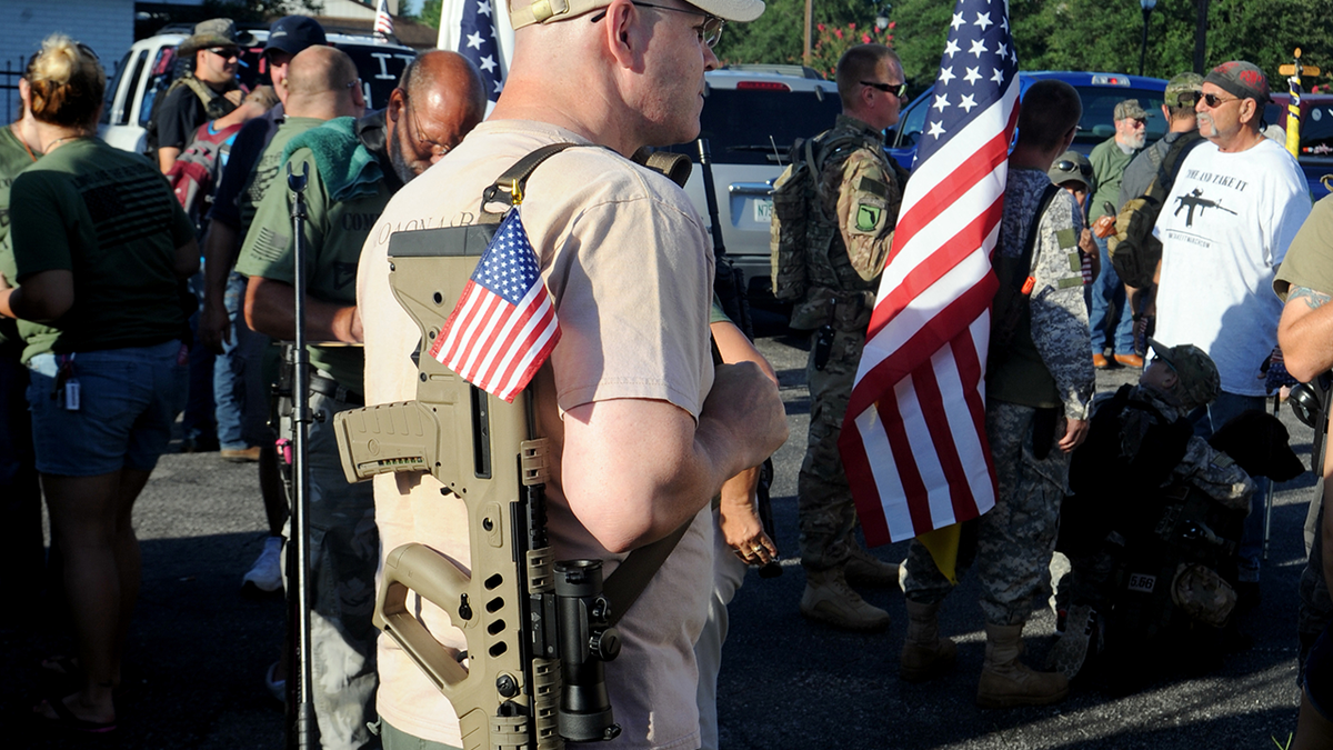 Gun rights proponent marches with firearm 