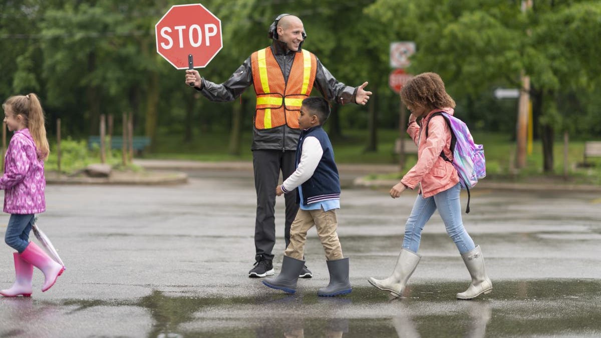 Crossing guard helps children get across street
