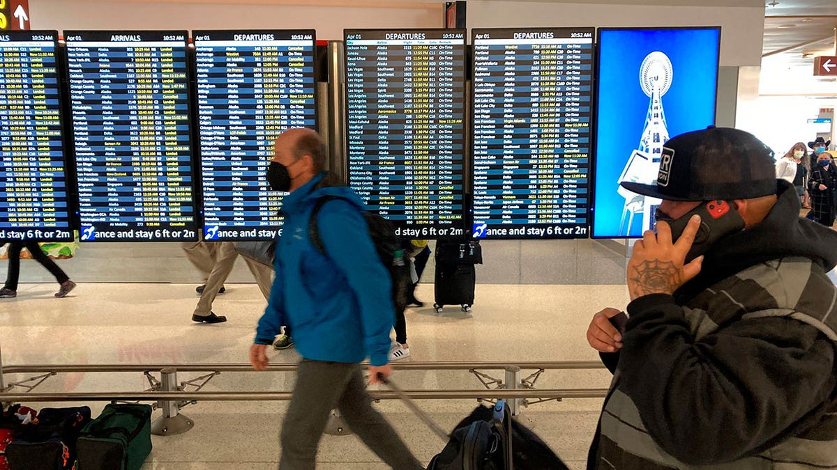 Travelers walk through Seattle-Tacoma International Airport on Friday, April 1, 2022 in Seattle. On Monday, April 18, 2022, a federal judge in Florida voided the national mask mandate covering airplanes and other public transportation saying it exceeded the authority of U.S. health officials.