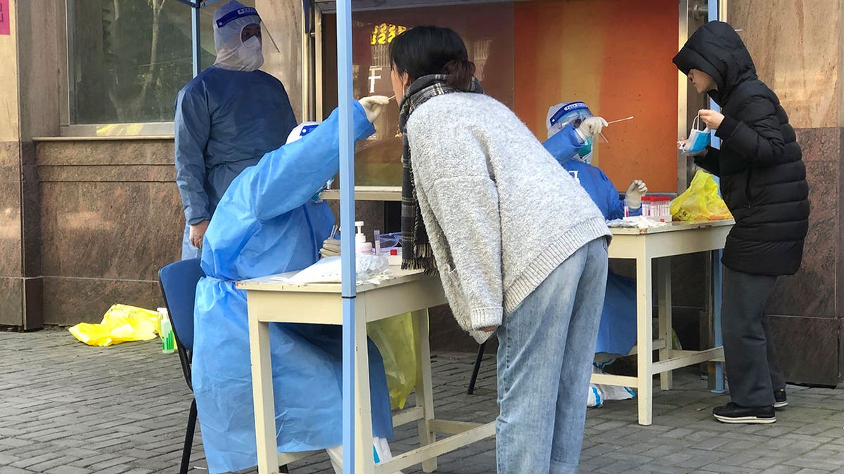 Medical workers conduct mass testing for residents in a lockdown area in the Jingan district of western Shanghai