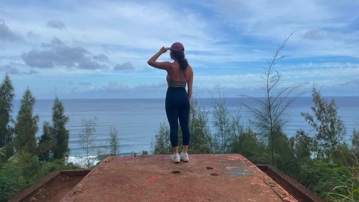 Girl stands on pillbox bunker in Oahu, HI