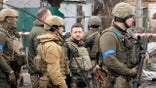 Ukrainian President Volodymyr Zelenskyy examines the site of a recent battle in Bucha, close to Kyiv, Ukraine, Monday, Apr. 4, 2022. Russia is facing a fresh wave of condemnation after evidence emerged of what appeared to be deliberate killings of civilians in Ukraine. (AP Photo/Efrem Lukatsky)