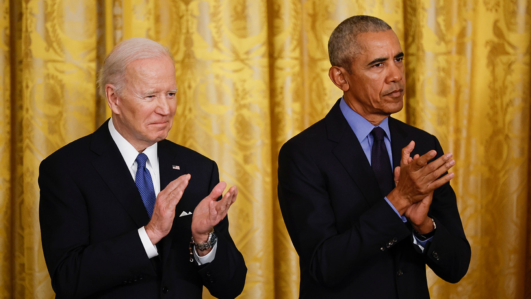 Biden and Obama sharing a stage, clapping their hands