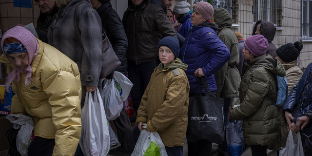 Sergei, 11, waits his turn to receive donated food during an aid humanitarian distribution in Bucha, in the outskirts of Kyiv, on Tuesday.