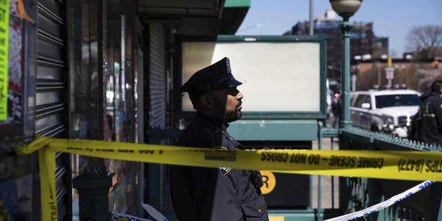 A police officer stands watch at the entrance of 36th Street Station after multiple people were shot on a subway train, Tuesday, April 12, 2022, in the Brooklyn borough of New York.