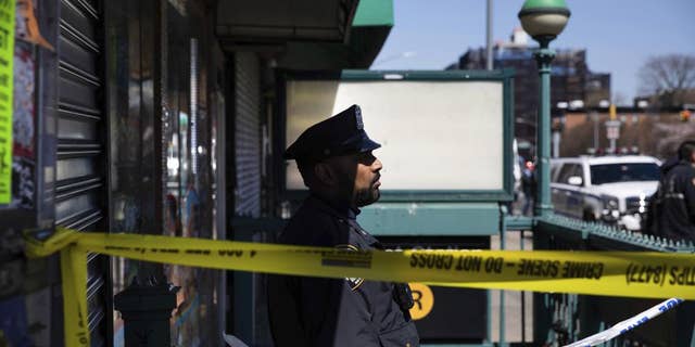 A police officer stands watch at the entrance of 36th Street Station after multiple people were shot on a subway train, Tuesday, April 12, 2022, in the Brooklyn borough of New York.