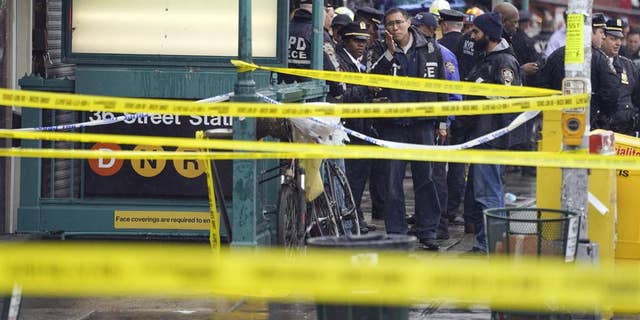 New York City Police Department personnel gather at the entrance to a subway stop in the Brooklyn borough of New York April 12, 2022.