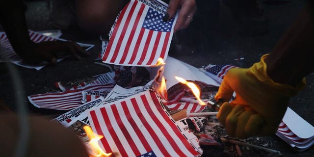 A group of protesters burned American flags and leaflets with the flag, although other protesters disagreed with the action during a protest against racial inequality and police violence near Black Lives Matter Plaza in Washington, DC, on July 4, 2020.  