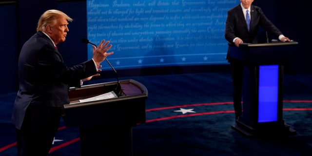 President Donald Trump answers a question as Democratic presidential candidate Joe Biden listens during the final presidential debate at Belmont University in Nashville, Tennessee, on Oct. 22, 2020.