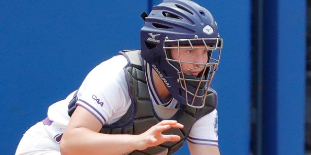 Oklahoma’s Rylie Boone (0) slides in at home past James Madison catcher Lauren Bernett (22) to score a run in the sixth inning during a Women’s College World Series semi finals game at USA Softball Hall of Fame Stadium. Oklahoma won 6-3.