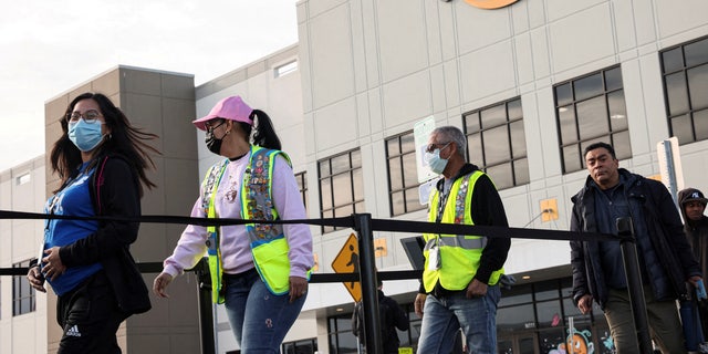 Workers stand in line to cast ballots for a union election at Amazon's JFK8 distribution center in the Staten Island borough of New York March 25, 2022.  