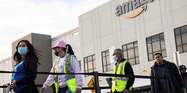Workers stand in line to cast ballots for a union election at Amazon's JFK8 distribution center in the Staten Island borough of New York March 25, 2022.