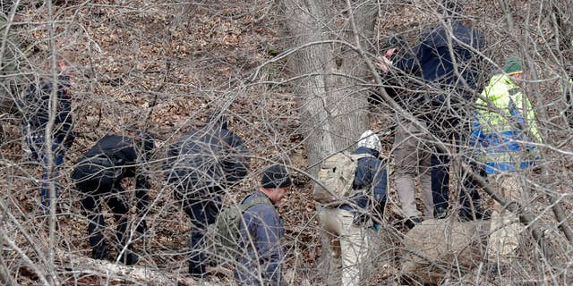 Officials search a wooded area next to the Jacob Leinenkugel Brewing Co. during an investigation of the homicide of Iliana "Lily" Peters, 10, in Chippewa Falls on Tuesday. Lilly's body was found about 9:15 a.m. Monday in a wooded area near the walking trail, according to police.