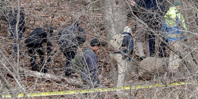 Officials search a wooded area next to the Jacob Leinenkugel Brewing Co. during an investigation of the homicide of Iliana "Lily" Peters, 10, in Chippewa Falls.
