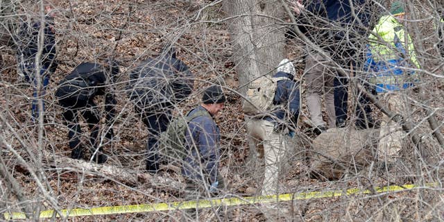 Officials search a wooded area next to the Jacob Leinenkugel Brewing Co. during an investigation of the homicide of Iliana "Lily" Peters, 10, in Chippewa Falls. Lilly's body was found in a wooded area near the walking trail, according to police.