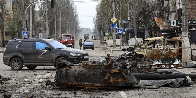 A part of a destroyed tank and a burned vehicle sit in an area controlled by Russian-backed separatist forces in Mariupol, Ukraine, on Saturday, April 23.