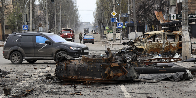 A part of a destroyed tank and a burned vehicle sit in an area controlled by Russian-backed separatist forces in Mariupol, Ukraine, on Saturday, April 23.