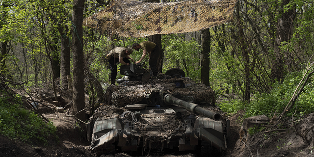 Ukrainian servicemen install a machine gun on a tank after fighting against Russian forces in the Donetsk region of eastern Ukraine on Wednesday, April 27.