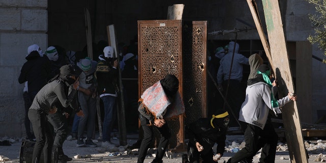 Palestinians clash with Israeli security forces at the Al Aqsa Mosque compound in Jerusalem's Old City Friday, April 15, 2022.
