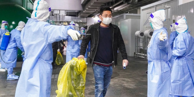 In this photo released by China’s Xinhua News Agency, COVID-19 patients leave a makeshift hospital at the National Exhibition and Convention Center in Shanghai, Thursday, April 14, 2022. Anti-virus controls that shut down some of China’s biggest cities and fueled public irritation are spreading as infections rise, hurting a weak economy and prompting warnings of possible global shockwaves.