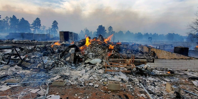 This Wednesday April 20, 2022, photo provided by Bill Wells shows his home on the outskirts of Flagstaff, Ariz., destroyed by a wildfire on Tuesday, April 19, 2022. The wind-whipped wildfire has forced the evacuation of hundreds of homes and animals. 