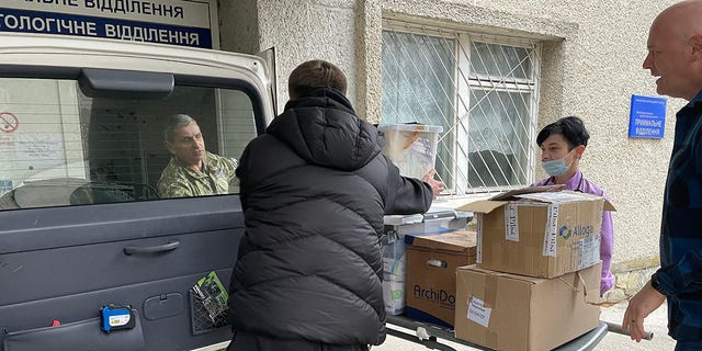 Dr. Daniel Smith assists with the unloading of medical supplies to a hospital in Ukraine. 